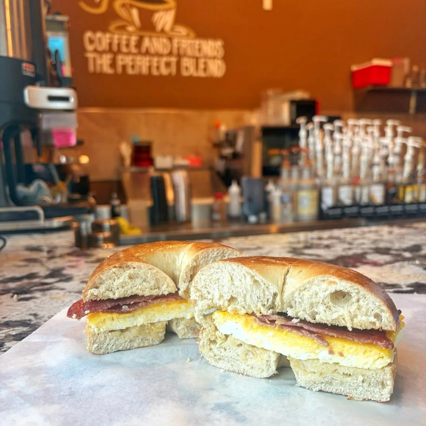 Fresh egg and bacon breakfast bagel on the café counter